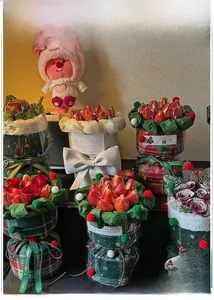Close-up of Christmas bouquet with strawberries, roses and red-green plaid fabric wrap