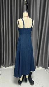 Side view of dark blue denim maxi dress with waist cinching and detailed stitching