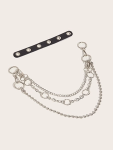 Detail of silver double-layered metal trousers chain with black eyelet leather accessory