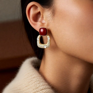 Gros plan détaillé de boucles d'oreilles vintage avec pierre rouge et zircons sur modèle