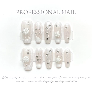 Detail of white 3D camellia press-on nails with silver glitter and rhinestone accents