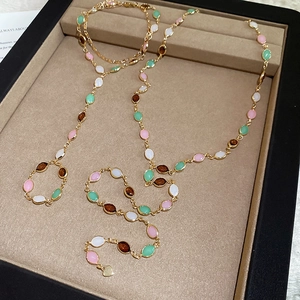 Elegant gold chain necklace with colorful oval beads in a velvet jewelry display box