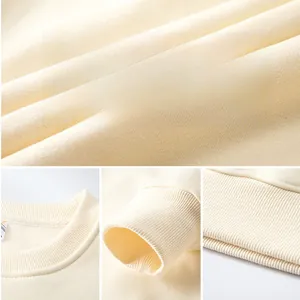 Macro texture of beige knit fabric with details of the ribbed neck, cuffs, and hem