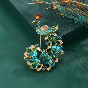 Détails de la broche paon vintage avec cristaux colorés et strass bleus sur fond vert