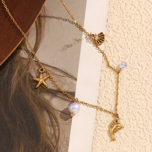 Detailed shot of 18K gold plated ocean pendants with starfish, shell and dolphin motifs