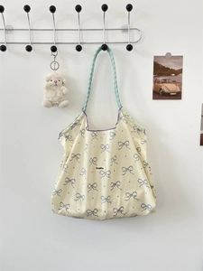 Close-up of floral tote bag with blue bow prints and mint green checkered handle