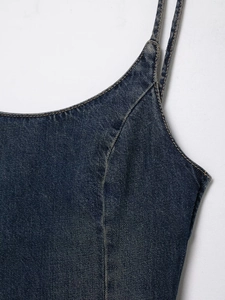 Detailansicht eines dunkelblauen Denim-Midikleids mit Spaghettiträgern und Kontrastnähten