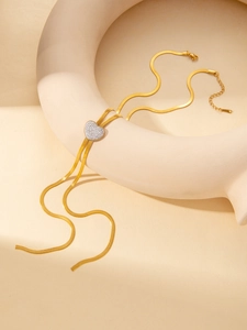 Détail du pendentif cœur doré serti de zircons sur une chaîne serpent chic