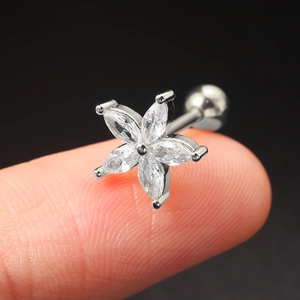 Macro shot of silver zircon flower stud earring with five marquise petals on fingertips