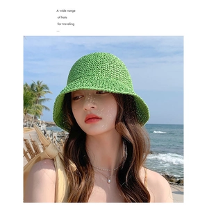 Close-up of vibrant green woven straw bucket hat with textured knit detail for summer beach travel