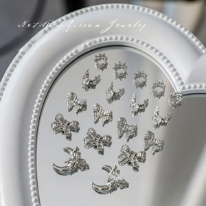 Détails de bijoux d'ongles en argent avec zircons couronne, nœud et lune sur plateau