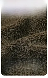 Macro shot of dark brown sherpa fleece fabric showing thick and breathable texture