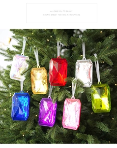 Detail of multi-colored faceted acrylic gem ornaments hanging on a Christmas tree