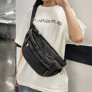 Unisex black washed denim crescent chest bag with adjustable strap and leather details
