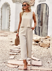 Detail of beige sleeveless top and wide-leg trousers in breathable linen blend fabric