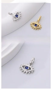 Macro detail of S925 sterling silver evil eye pendants with blue gemstones and gold finish