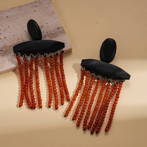 Ethnic wood style earrings with black oval tops and vibrant orange red bead tassels