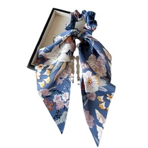 Blue floral satin scrunchie with long ribbons on a gift box, elegant hair accessory
