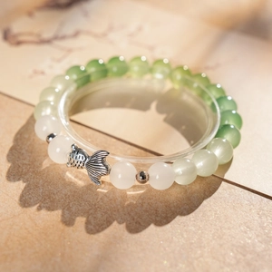 Detailed view of beaded bracelet with fish charm and green gradient chalcedony beads