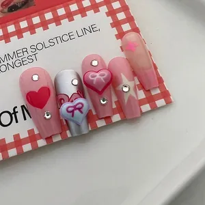 Pink and silver Y2K press-on nails with resin bows and heart-shaped charms