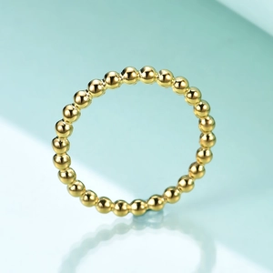Detailed macro shot of a gold-colored minimalist geometric bead ring with smooth finish