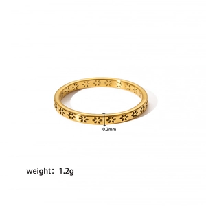 Detailed macro view of minimalist golden stainless steel ring with hollow flower design