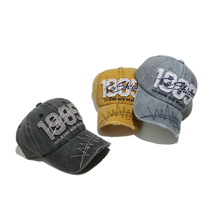 Close-up of three vintage washed baseball caps with 1985 3D embroidery and distressed brims