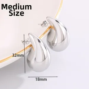 Detail of medium size silver teardrop earrings with 32mm height and 18mm width dimensions