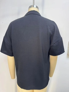 Detail of black short-sleeve shirt back view showing the unique textured crinkle fabric
