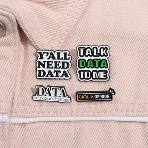 Close-up of four geeky DATA themed enamel pins pinned on a pink denim jacket