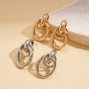 Detailed view of interconnected gold and silver chain link earrings on a stone display