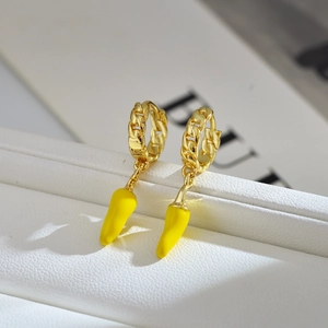 Detailed macro view of yellow chili pepper earrings with gold plated chain links