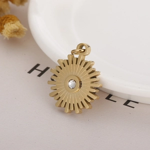 Minimalist golden stainless steel sunburst pendant with zircon stone on white surface