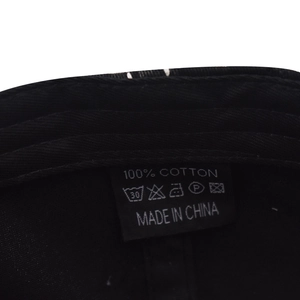 Macro detail of the 100% cotton fabric label and washing instructions on baseball cap