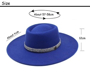 Detail view of the deep blue felt fedora with a rhinestone belt and 'M' metal pendant