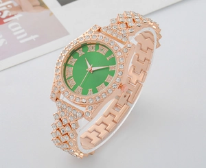 Macro side view of luxury rose gold watch with emerald green dial and crystal bezel