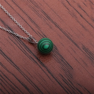Detailed close-up of green malachite round pendant on a silver-tone chain necklace