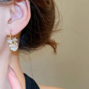 Close-up of 18k gold plated floral petal earrings worn on a model with elegant details