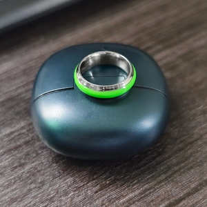 Macro view of glowing green fluorescent inlay on a polished stainless steel ring