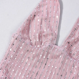 Détail macro de paillettes argentées sur tissu côtelé rose pour un ensemble haut court sexy