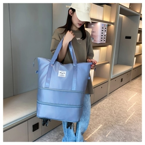 Detail of light blue travel bag with universal wheels and expandable bottom layer