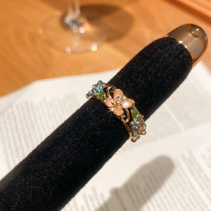 Macro shot of vintage floral gold ring with colorful enamel petals and tiny crystals