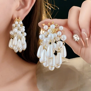 Detailed view of elegant gold tassel earrings with cascading white drop pearls