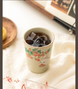Close-up of Ru-ware ceramic tea cup with cute strawberry and rabbit patterns