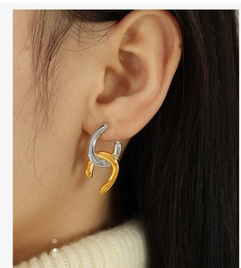 Detailed close-up of mixed gold and silver geometric interlocking chain loop earrings