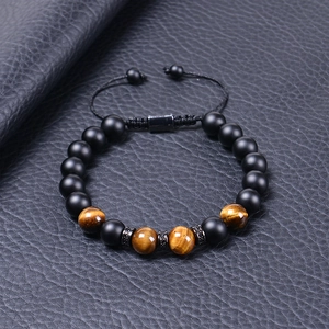 Macro detail of Tiger Eye and Lava stone beads with braided cord on blue leather
