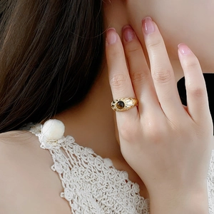 Nahaufnahme eines Vintage-Goldrings mit braunem Tigerauge-Stein und Kristallen