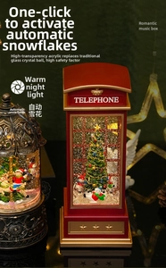 Close-up of a red telephone booth music box with rotating Christmas tree and snow effect