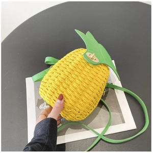 Detailed view of handmade woven pineapple shoulder bag with green leaf lid and metal clasp