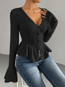 Detailed view of the ribbed knit texture and ruffled peplum hem on this black V-neck top